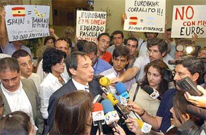 Javier Fondevilla habla con los periodistas rodeado de pancartas de protesta.