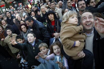 Niños con sus familiares miran a los Reyes Magos durante la cabalgata del 5 de enero de 2011 en Sevilla.