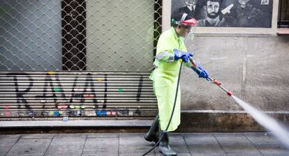 Un trabajador municipal limpiando en una calle de Barcelona los orines de los incívicos.