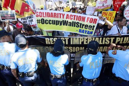 Policías antidisturbios forman una barrera frente a los participantes de la manifestación convocada frente a la embajada de EE UU en apoyo al movimiento "Occupy Wall Street", en Manila (Filipinas).