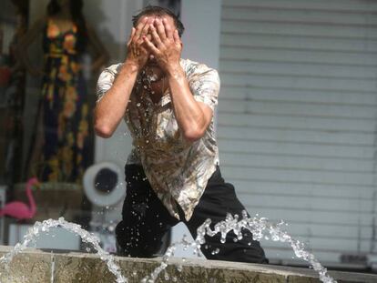 Un hombre intenta refrescarse en una fuente de Córdoba el 4 de julio.