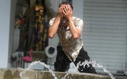 Un hombre intenta refrescarse en una fuente de Córdoba el 4 de julio.
