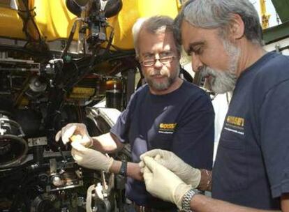 Greg Stemm y Tom Dettweiler, de Odyssey, examinan una de las monedas recuperadas del llamado <i>Cisne Negro</i>.