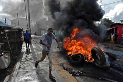 Un manifestante pasa junto a una barricada ardiendo en Kibera (Kenia).