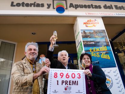 Los propietarios de la administración número 1 de L'Escala (Girona) posan con el número agraciado con el primer premio de la Lotería de El Niño, este viernes.