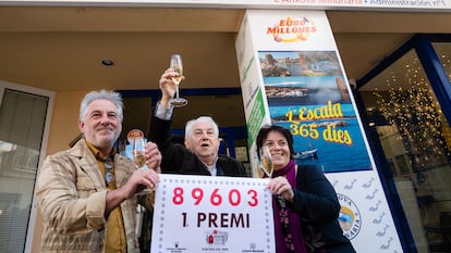 Los propietarios de la administración número 1 de L'Escala (Girona) posan con el número agraciado con el primer premio de la Lotería de El Niño, este viernes.