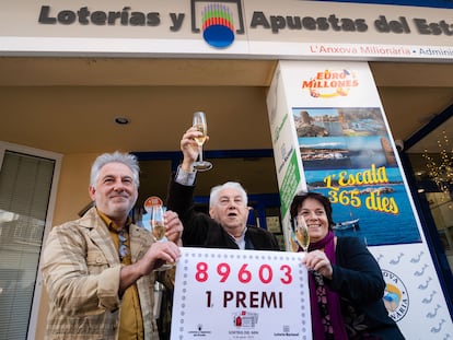 Los propietarios de la administración número 1 de L'Escala (Girona) posan con el número agraciado con el primer premio de la Lotería de El Niño, este viernes.