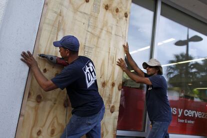 El poderoso huracán María se dirige a Puerto Rico con vientos de hasta 250 kilómetros por hora. En la imagen dos hombres clavan tablones en las ventanas de su tienda para protegerlo de la llegada de María en la capital San Juan.