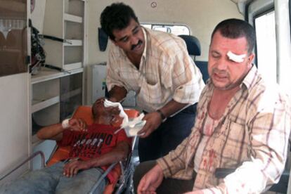 Dos iraquíes son evacuados en ambulancia tras el atentado que ha dejado hoy 15 heridos en un hospital de Bagdad.