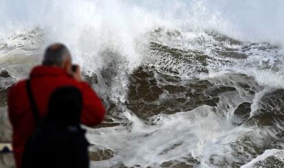 Una persona fotografía el estado del mar junto a la playa del Camello, en Santander