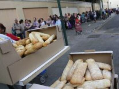 Cola de personas espera un reparto de comida del Banco de Alimentos en Valencia.