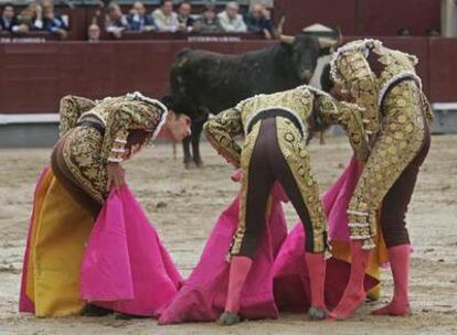 Matías Tejela, a la izquierda, y Enrique Ponce, en el centro, auxilian a El Cid, que acaba de ser cogido en su primer toro.