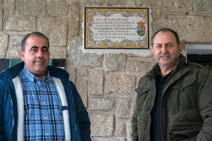 Julio Muñoz y Miguel Ángel Sánchez, delante de la placa del Ayuntamiento en Pueblonuevo de Miramontes, en Cáceres. 