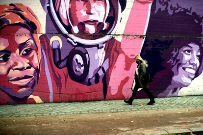 Una mujer pasa por el mural feminista en el polideportivo municipal de la Concepción en el distrito de Ciudad Lineal.