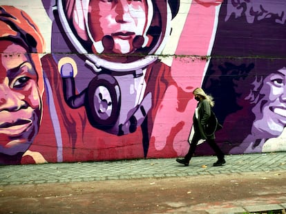 Una mujer pasa por el mural feminista en el polideportivo municipal de la Concepción en el distrito de Ciudad Lineal.