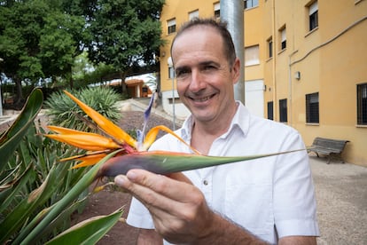 Paco Calvo holding a Strelitzia reginae (crane flower) specimen at the University of Murcia.