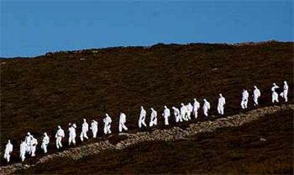 Un grupo de soldados se encamina a limpiar chapapote en el cabo Vilán, en el noroeste de la costa gallega.