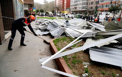 Efectivos de Protección Civil se disponen a apartar las piezas del tejado de un edificio en la calle Alcalde Portanet de Vigo, el 3 de febrero de 2017.