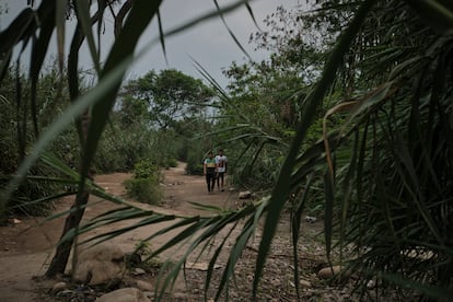 Dos jóvenes cruzan una la trocha La Platanera en la frontera entre Colombia y Venezuela.