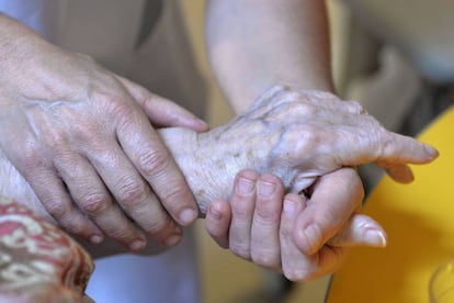 Una persona atiende a una anciana.