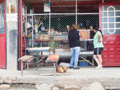 Dos mujeres compran abarrotes en una tienda en un barrio de escasos recursos en Bogotá (Colombia).