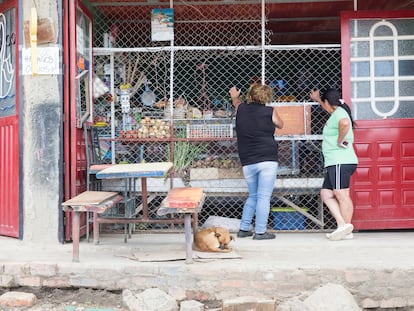 Dos mujeres compran abarrotes en una tienda en un barrio de escasos recursos en Bogotá (Colombia).