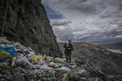 Un miner torna a casa caminant per un precipici inundat per escombraris de plàstoc d'un sol ús. La Rinconada, Perú.