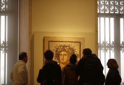 Visitantes observan el mosaico del 'Genio del año', en la primera planta del Museo Arqueológico.