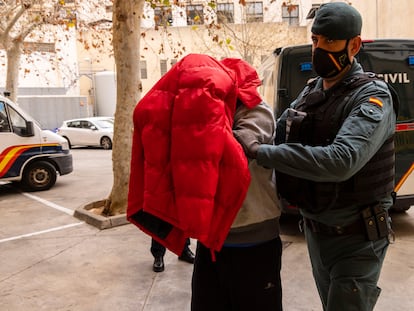 Uno de los detenidos por el espionaje a una mujer en Mallorca entre en el juzgado de Palma, este miércoles, custodiado por un guardia civil.