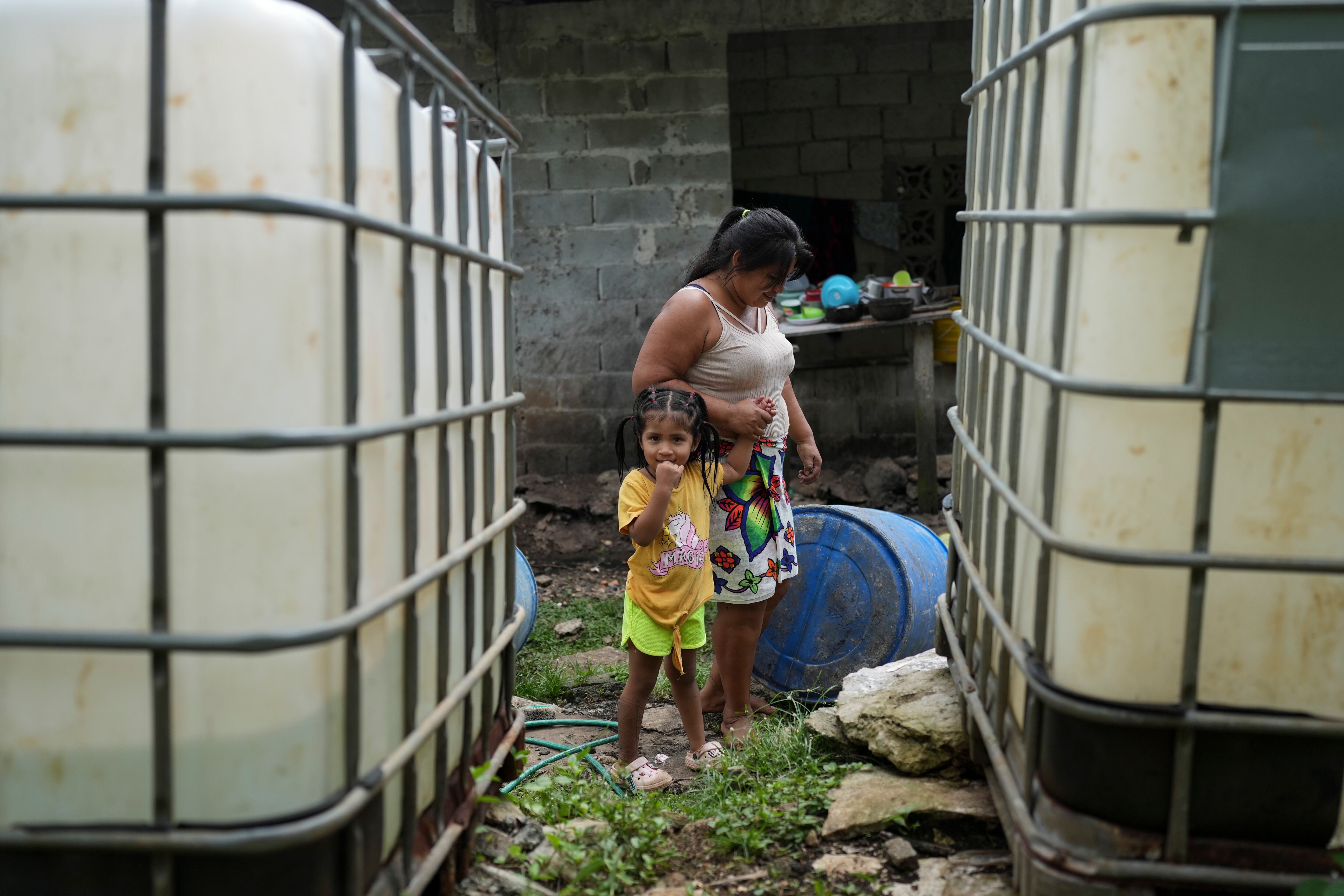 Berta Dumasa camina con su hija en su casa de Puerto Corotu.