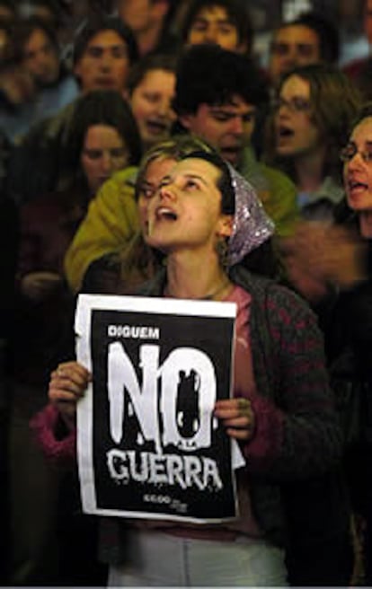 Una estudiante muestra un cartel con la leyenda "digamos no a la guerra" en valenciano ante la sede del PP en Valencia. Centenares de estudiantes protestaron por el inicio de los ataques contra Irak en la Comunidad Valenciana.