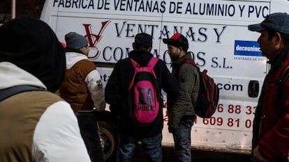 Jorge Luis, de espaldas a la izquierda, espera en Usera cada mañana a que le ofrezcan trabajo como albañil.