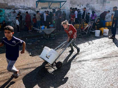 Un grupo de palestinos llenan garrafas de agua en Rafah, al sur de la franja de Gaza, este lunes.