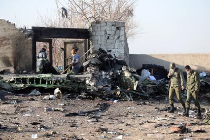 Soldados iranianos caminham pelos restos do avião ucraniano derrubado que deixou 176 pessoas mortas