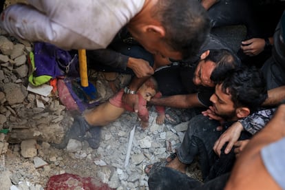 Un grupo de palestinos rescata a un niño de los escombros tras un bombardeo israelí en Rafah, en el sur de la Franja.
