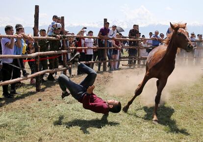 Un participante cae al suelo después de montar a un caballo, en el Festival Internacional de Cultura Nómada de Almaty (Kazajstán), el 7 de junio de 2019.