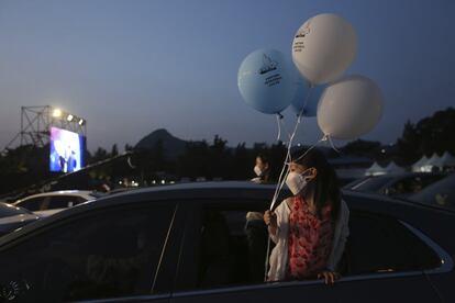 Una joven asiste a un concierto desde la ventana trasera de un coche, en Seúl (Corea del Sur). El país vuelve a alcanzar los 60 contagios en medio de un repunte de casos locales e importados. 