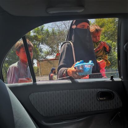 Una mujer vendía chicles, en compañía de sus hijos, en una concurrida calle de la capital afgana.
