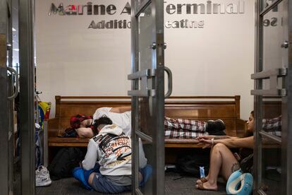 Una persona duerme mientras espera en la zona de salidas de Spirit Airlines en el aeropuerto LaGuardia, en Nueva York.