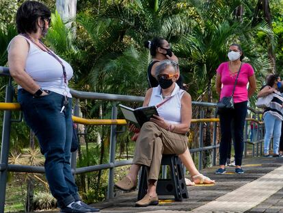 Varias personas hacen una fila en un centro de salud mientras esperan ser vacunadas contra la covid-19 en San José, Costa Rica.