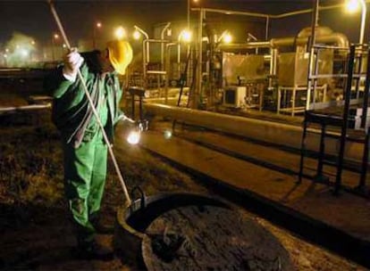 Un obrero emplea un palo especial para comprobar el nivel de crudo en un tanque de almacenaje subterráneo en la estación de recepción del oleoducto de Druzhba en Szazhalombatta, a 29 kilómetros al sur de Budapest, después de que el suministro de petróleo que llega a Hungría desde Rusia haya sido cortado debido a una disputa de precios entre Rusia y Bielorrusia.