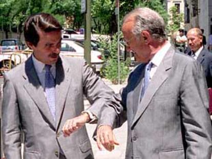 Aznar y el presidente del Poder Judicial, Javier Delgado, bromean sobre el parecido de sus trajes.