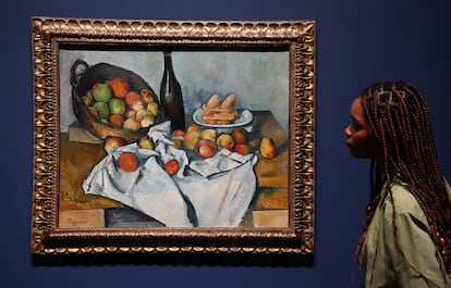 Una empleada de la Tate Modern contempla La Cesta de Manzanas de Cézanne, incluida en la exposición antológica del artista