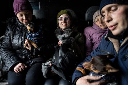 Arina, center, rides inside a car with her family during an evacuation by Ukrainian police, in Avdiivka, Ukraine, Tuesday, March 7, 2023