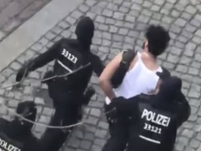 Um suspeito é levado pela polícia neste domingo em Berlim.