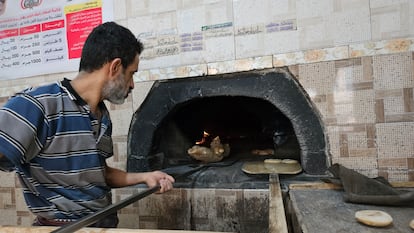 Un panadero usando un horno de leña en Saná.