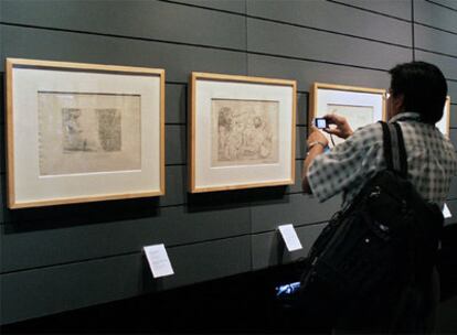 Un hombre fotografía un grabado de Pablo Picasso perteneciente a la colección 'Suite Vollard'.