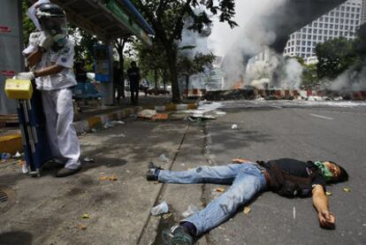 El cadáver de un <i>camisa roja</i> yace en una calle tras los disturbios en el centro de Bangkok.