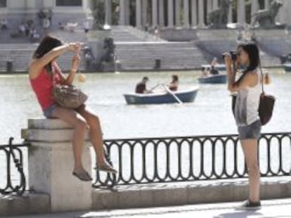 Dos turistas chinas se fotograf&iacute;an en el parque del Retiro de Madrid.