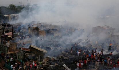 Un grupo de víctimas de un incendio intenta recuperar sus pertenencias de sus hogares, en Navotas (Filipinas).